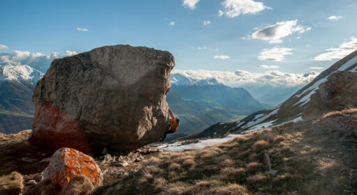 Young woman bouldering in the Swiss alps